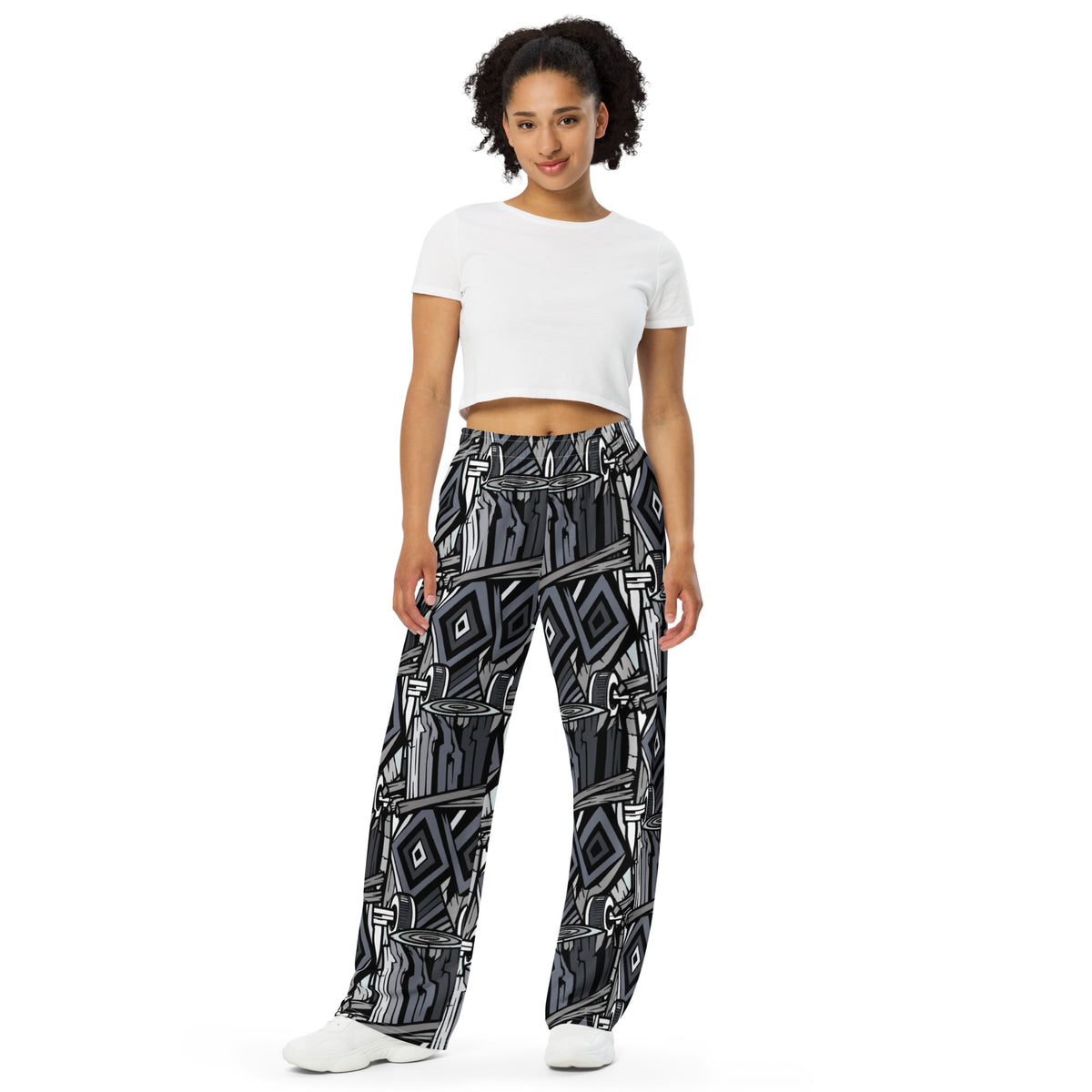 Wide-leg trousers featuring an all-over repeating abstract skateboard and wood-grain graphic pattern rendered in monochrome black, grey, and white tones.