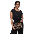 Black crossbody bag with a repeating Carnivore Skate Fridge print in orange, turquoise and grey.