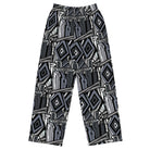 Front. Wide-leg trousers featuring an all-over repeating abstract skateboard and wood-grain graphic pattern rendered in monochrome black, grey, and white tones.