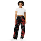 Wide-leg trousers featuring an abstract graphic of a black shadowed watcher figure riding a grey brick-patterned skateboard with red flowing ribbon-like strands extending downward.