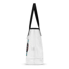 Neon Red puts a geometric red-and-turquoise skateboard design on a transparent tote bag with black handles.