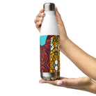 Stainless steel water bottle with an abstract city graphic and a black skateboard flying across a turquoise sky.